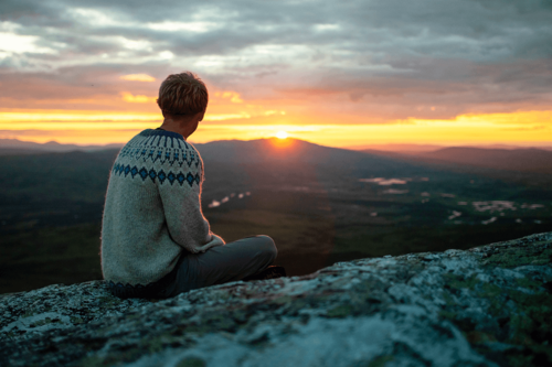 Person blickar ut över Jämtlandstriangeln i solnedgången