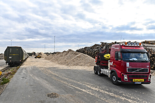 Stora lager av barkborreskadad rundved i Stockaryd. Flishuggen från Maskinflisning i Laxå flisar barkborrevirket.