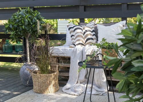 Mysigt uterum med soffa, filt, kuddar och växter